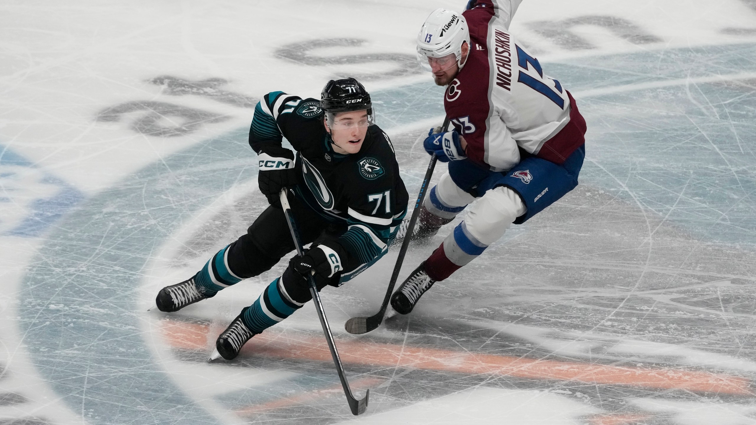 San Jose Sharks center Macklin Celebrini (71) skates with the puck against Colorado Avalanche right wing Valeri Nichushkin (13) during the third period of an NHL hockey game in San Jose, Calif., Thursday, Dec. 19, 2024. (AP Photo/Jeff Chiu)