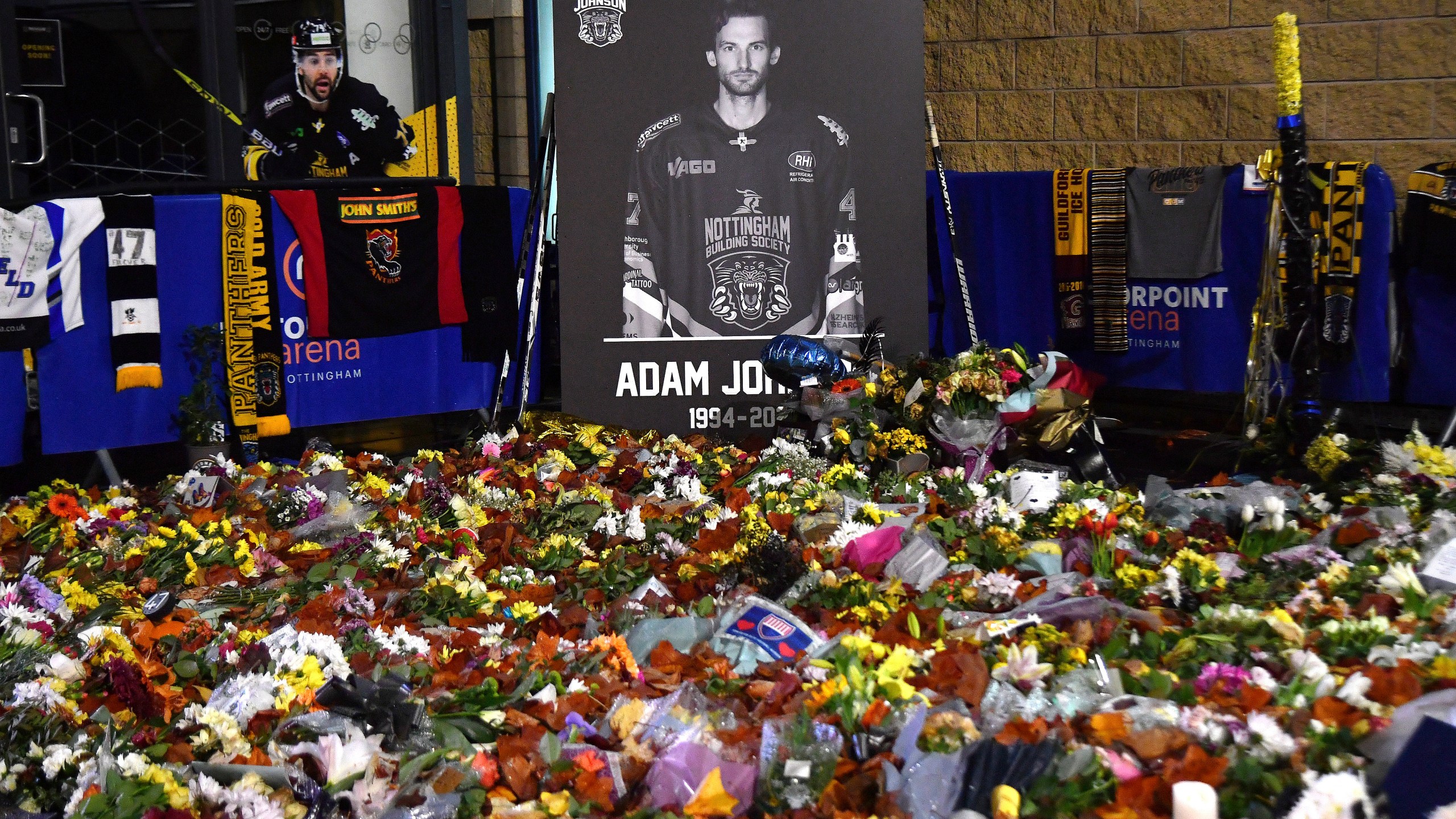 FILE - Flower tributes for Nottingham Panthers player Adam Johnson rest outside the Motorpoint Arena before a memorial ice hockey game between Nottingham Panthers and Manchester Storm in Nottingham, England, Nov. 18, 2023. (AP Photo/Rui Vieira, File)