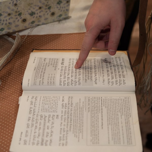 Dov Marcus points to prayers as he reads from the Jewish prayer book in Teaneck, N.J., on Friday, Dec. 20, 2024. (AP Photo/Luis Andres Henao)