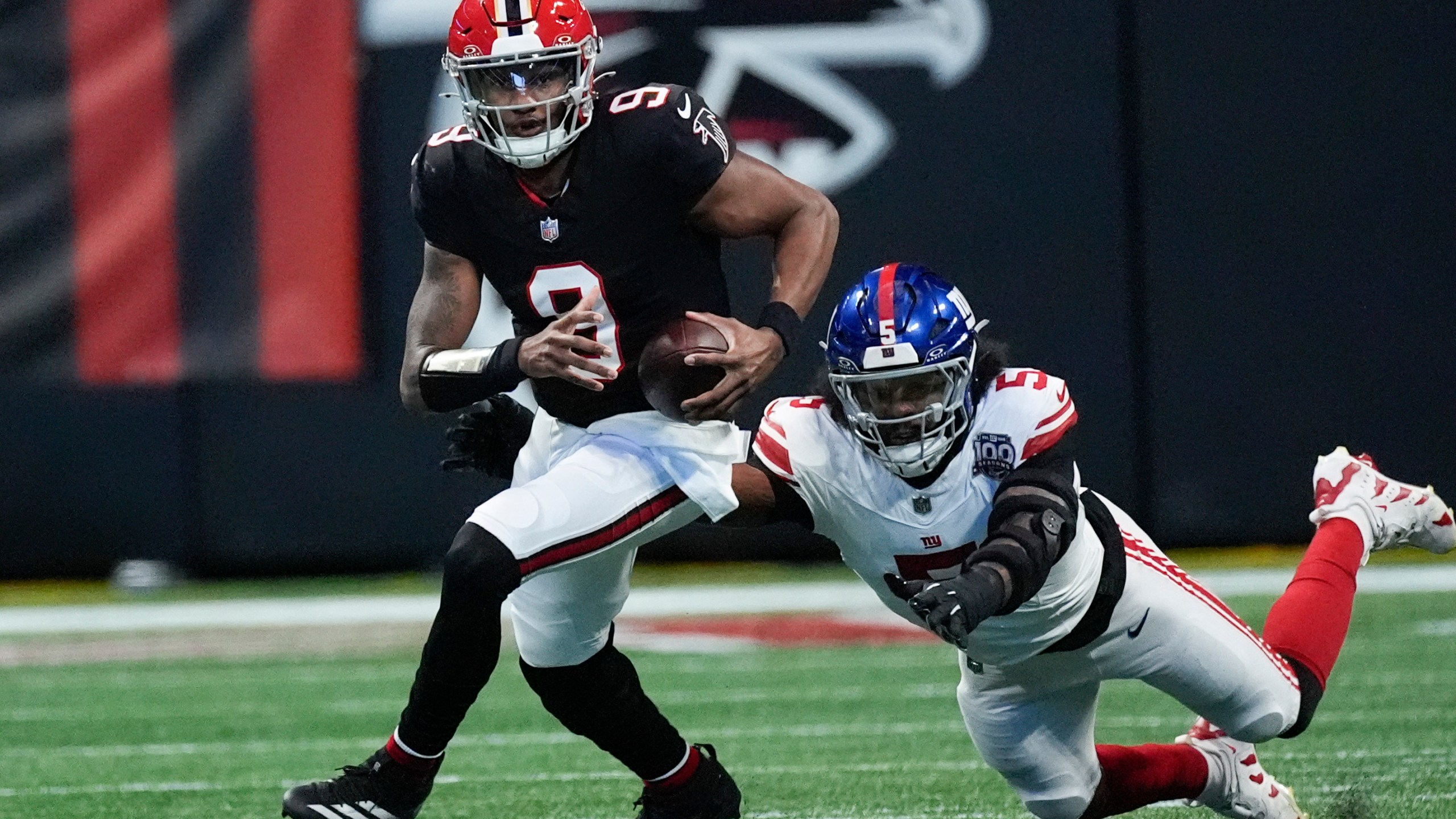 Atlanta Falcons quarterback Michael Penix Jr. (9) tackled by New York Giants linebacker Kayvon Thibodeaux (5) short of the first down in the first half of an NFL football game in Atlanta, Sunday, Dec. 22, 2024. (AP Photo/John Bazemore)