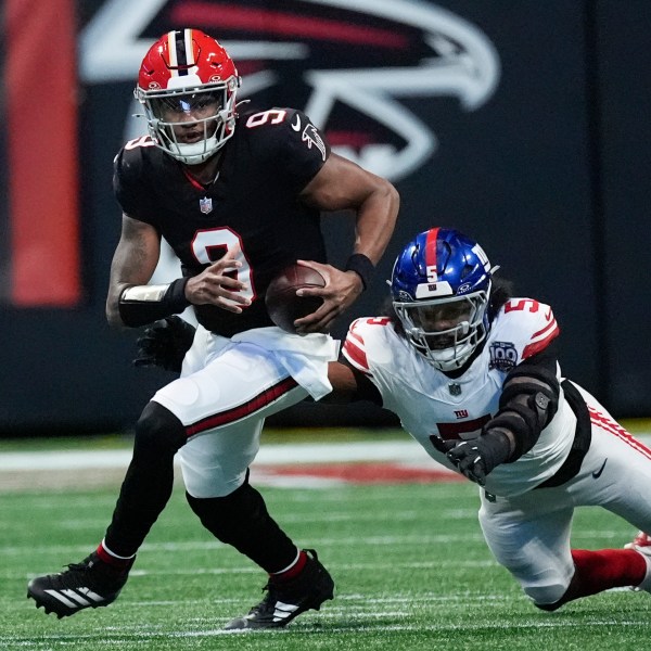 Atlanta Falcons quarterback Michael Penix Jr. (9) tackled by New York Giants linebacker Kayvon Thibodeaux (5) short of the first down in the first half of an NFL football game in Atlanta, Sunday, Dec. 22, 2024. (AP Photo/John Bazemore)