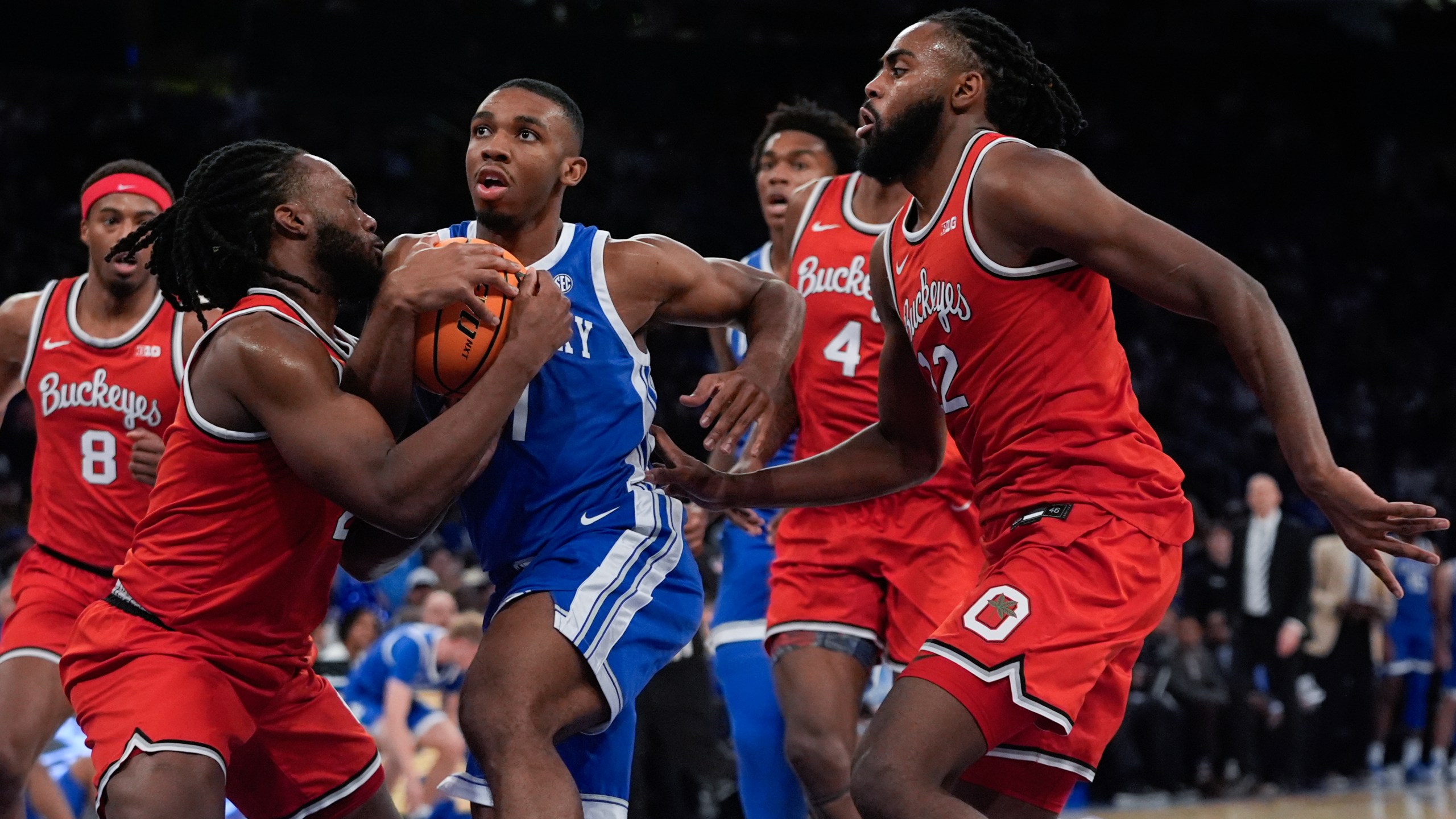 Ohio State's Bruce Thornton, left, fights for control of the ball with Kentucky's Lamont Butler as Evan Mahaffey, right, watches during the first half of an NCAA college basketball game in the CBS Sports Classic, Saturday, Dec. 21, 2024, in New York. (AP Photo/Frank Franklin II)