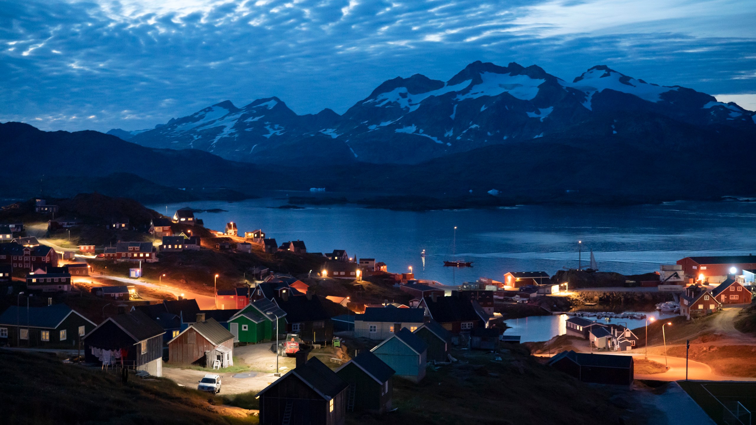 FILE - Homes are illuminated after the sunset in Tasiilaq, Greenland, Friday Aug. 16, 2019.(AP Photo/Felipe Dana, File)