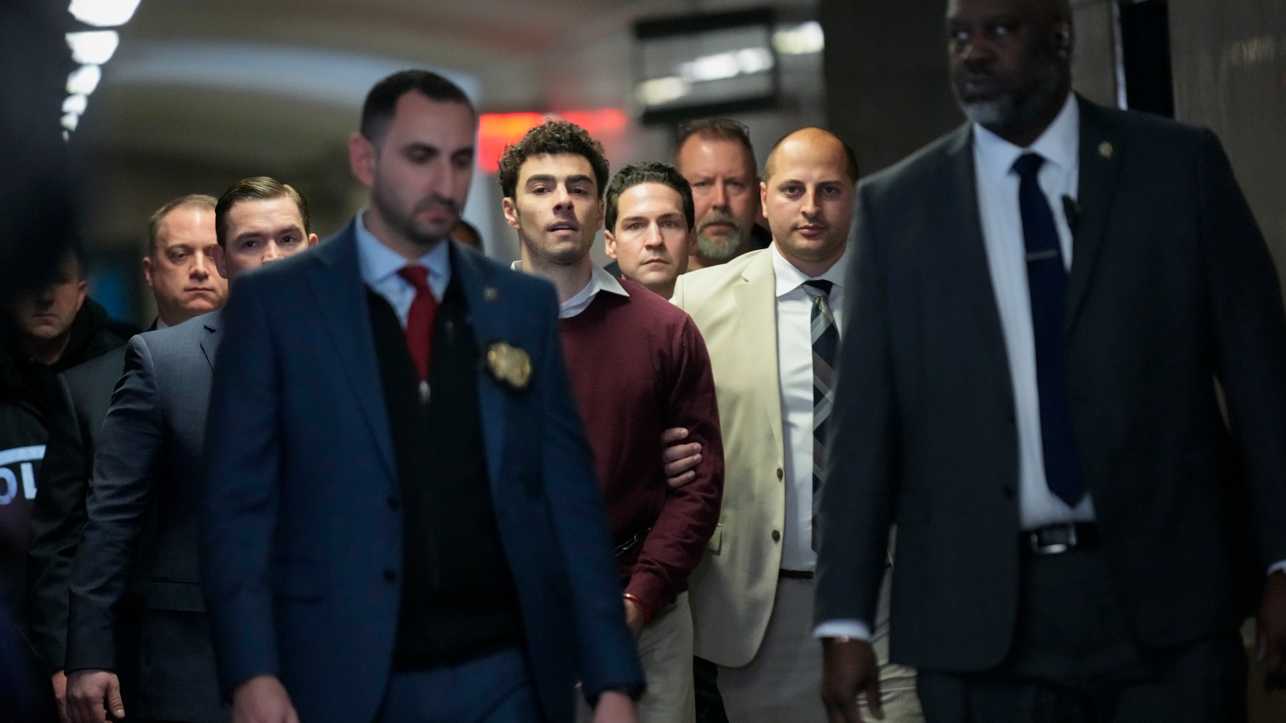 Luigi Mangione, center, is escorted into Manhattan Criminal court for his arraignment on state murder and terror charges in the killing of UnitedHealthcare CEO Brian Thompson, Monday, Dec. 23, 2024, in New York. (AP Photo/Seth Wenig)