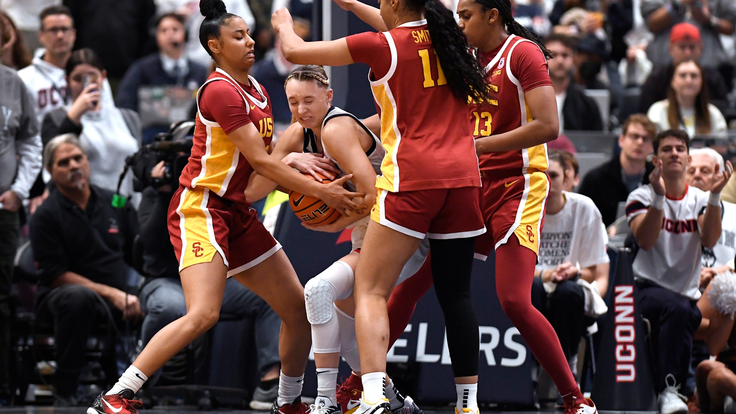 UConn guard Paige Bueckers, second from left, is pressured by Southern California guard JuJu Watkins, left, guard Kennedy Smith, second from right, and center Rayah Marshall, right, in the second half of an NCAA college basketball game, Saturday, Dec. 21, 2024, in Hartford, Conn. (AP Photo/Jessica Hill)