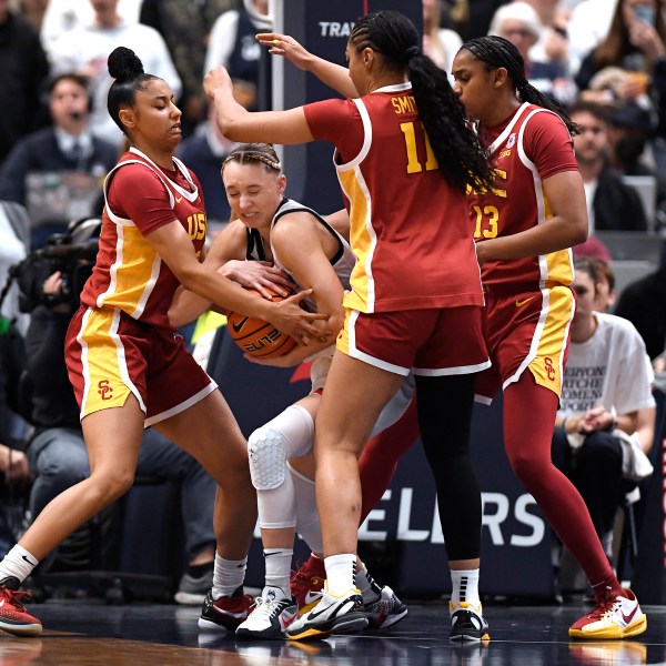 UConn guard Paige Bueckers, second from left, is pressured by Southern California guard JuJu Watkins, left, guard Kennedy Smith, second from right, and center Rayah Marshall, right, in the second half of an NCAA college basketball game, Saturday, Dec. 21, 2024, in Hartford, Conn. (AP Photo/Jessica Hill)