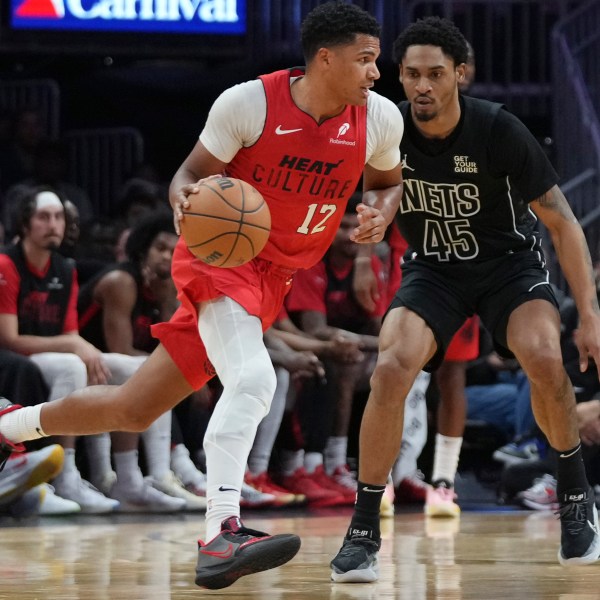 Miami Heat guard Dru Smith (12) dribbles as Brooklyn Nets guard Keon Johnson (45) defends during the first half of an NBA basketball game, Monday, Dec. 23, 2024, in Miami. (AP Photo/Lynne Sladky)