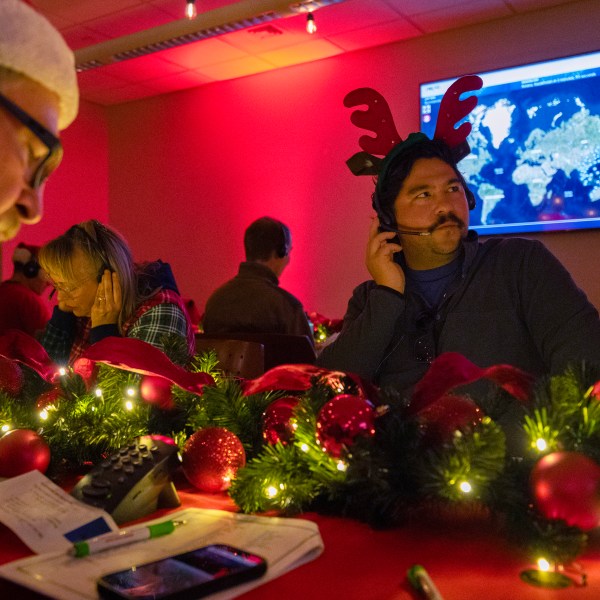 Volunteers answer phone calls from around the world Tuesday, Dec. 24, 2024, at the NORAD Tracks Santa center at Peterson Space Force Base in Colorado Springs, Colo. (Christian Murdock /The Gazette via AP)