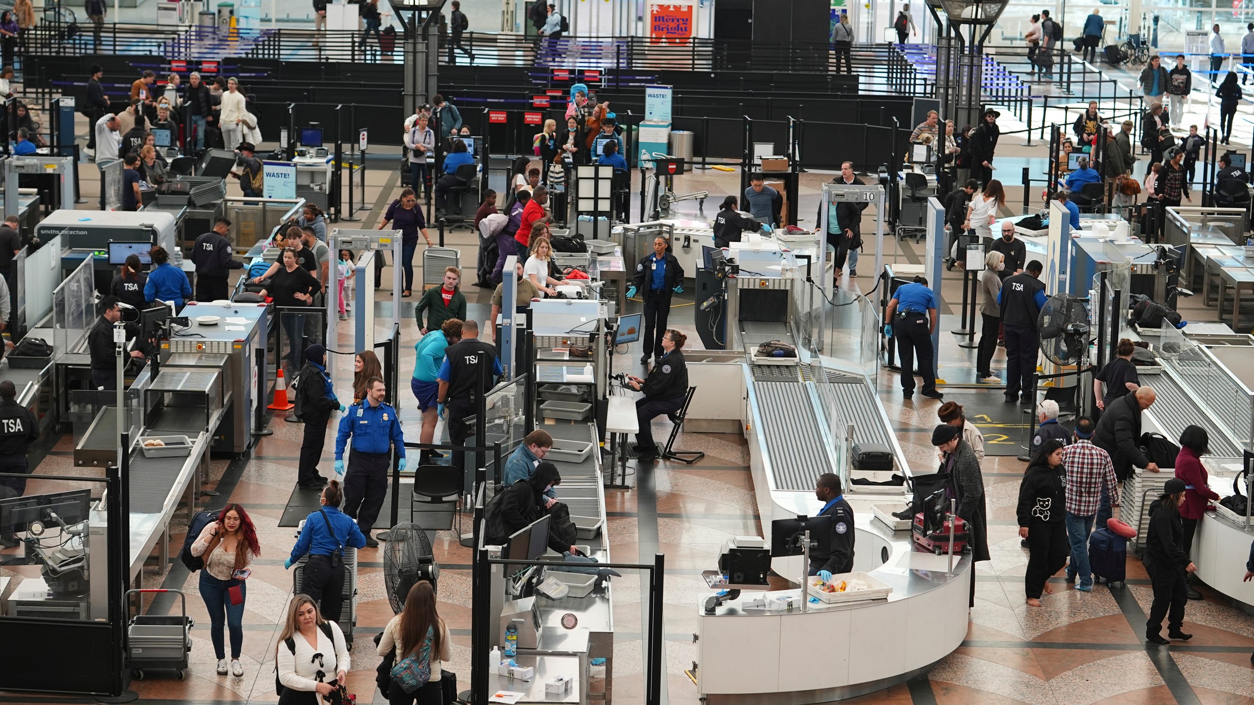 Travelers queue up to pass through the south security checkpoint in the main terminal of Denver International Airport Tuesday, Dec. 24, 2024, in Denver. (AP Photo/David Zalubowski)