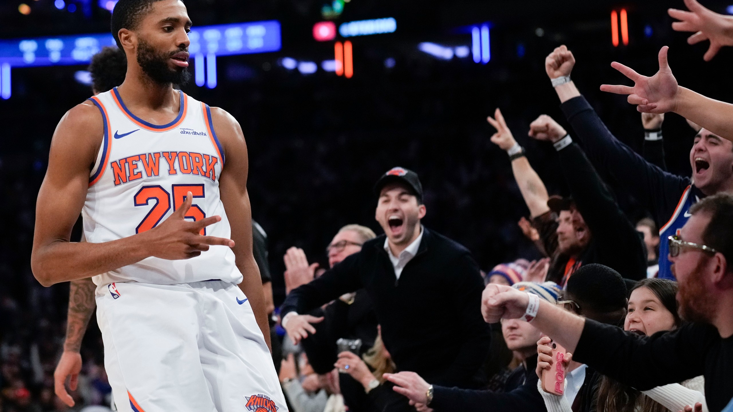 New York Knicks' Mikal Bridges, left, and fans react after Bridges hit a three point basket during the second half of an NBA basketball game, Wednesday, Dec. 25, 2024, in New York. The Knicks defeated the Spurs 117-114. (AP Photo/Seth Wenig)