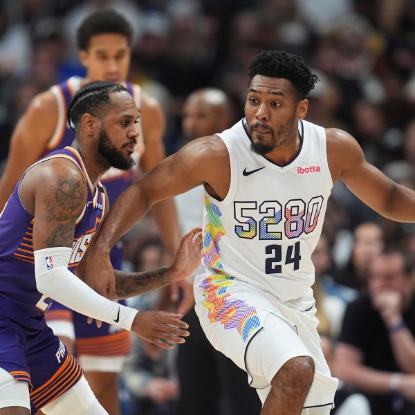 Denver Nuggets guard Jalen Pickett, right, drives past Phoenix Suns guard Monte Morris in the second half of an NBA basketball game Monday, Dec. 23, 2024, in Denver. (AP Photo/David Zalubowski)