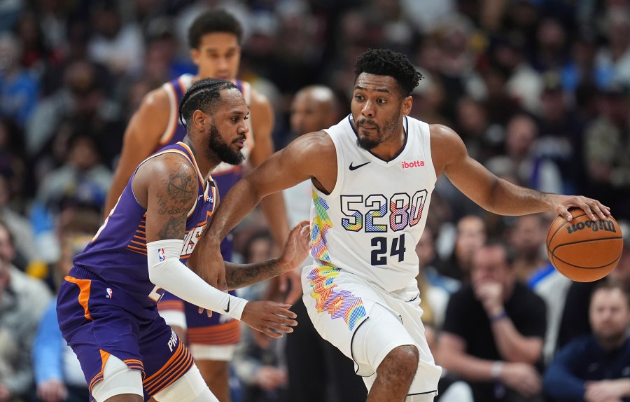 Denver Nuggets guard Jalen Pickett, right, drives past Phoenix Suns guard Monte Morris in the second half of an NBA basketball game Monday, Dec. 23, 2024, in Denver. (AP Photo/David Zalubowski)