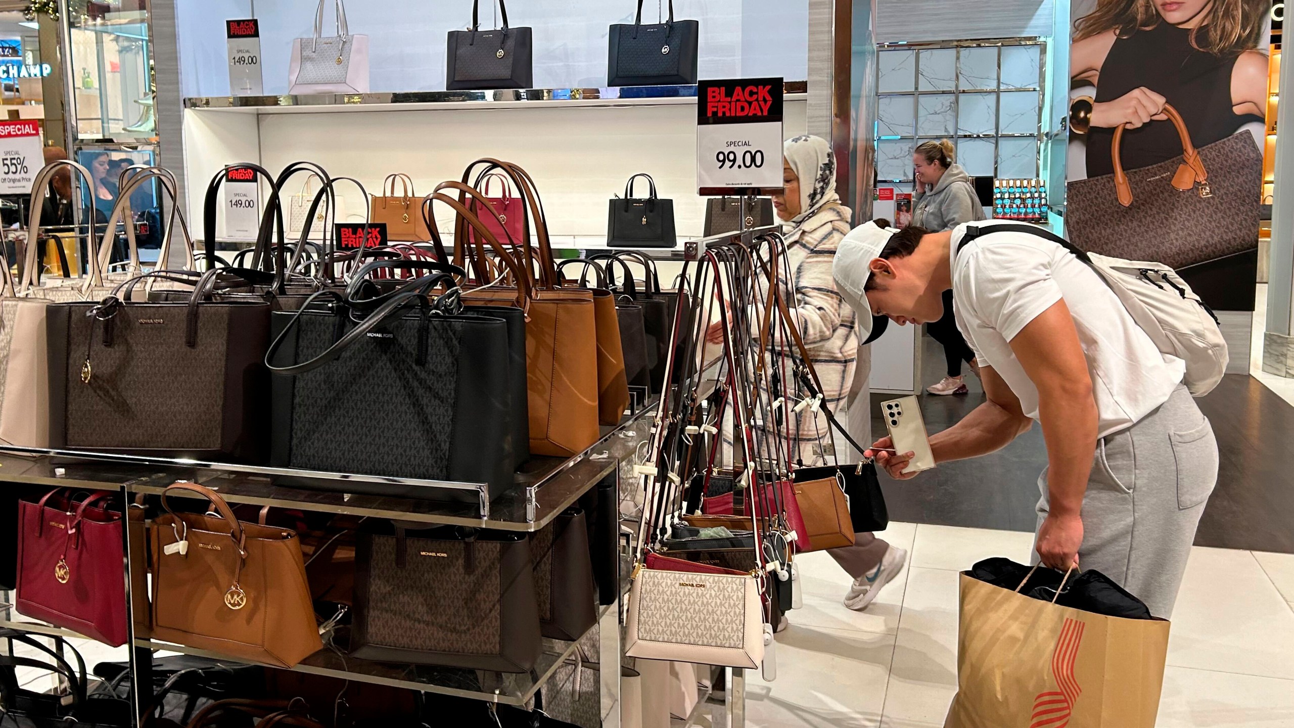 FILE - A shopper looks at handbags at Macy's department store on Sunday, Nov. 24, 2024, in New York. (AP Photo/Anne D'Innocenzio, File)