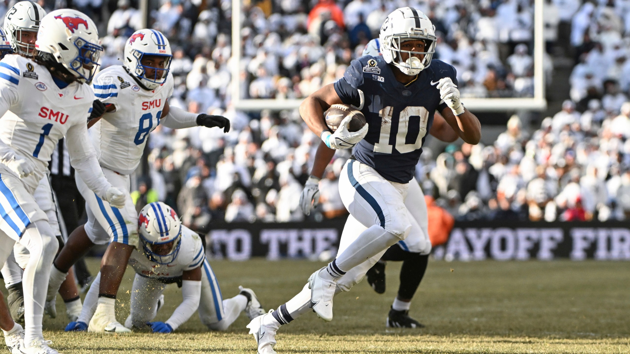 Penn State running back Nicholas Singleton (10) runs past SMU safety Brandon Crossley during the second half in the first round of the College Football Playoff, Saturday, Dec. 21, 2024, in State College, Pa. (AP Photo/Barry Reeger)