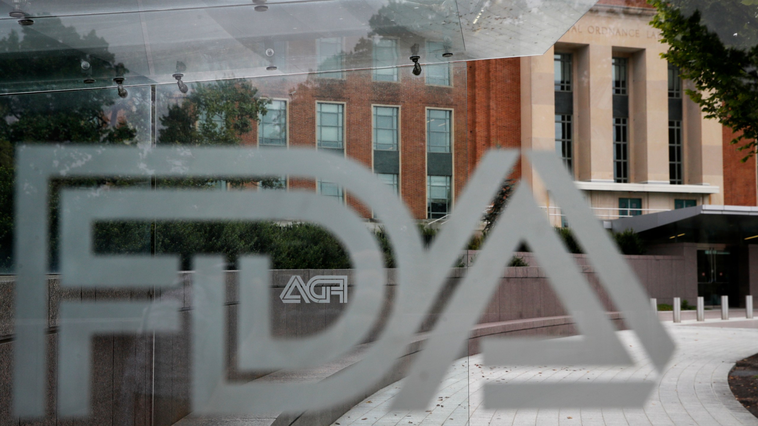 FILE - A U.S. Food and Drug Administration building is seen behind FDA logos at a bus stop on the agency's campus in Silver Spring, Md., on Aug. 2, 2018. (AP Photo/Jacquelyn Martin, File)