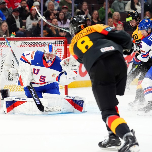 United Sttaes goaltender Trey Augustine (1) makes a glove-save against Germany forward Noah Samanski (8) during second-period IIHF World Junior Hockey Championship preliminary round game action in Ottawa, Ontario, Thursday, Dec. 26, 2024. (Sean Kilpatrick/The Canadian Press via AP)