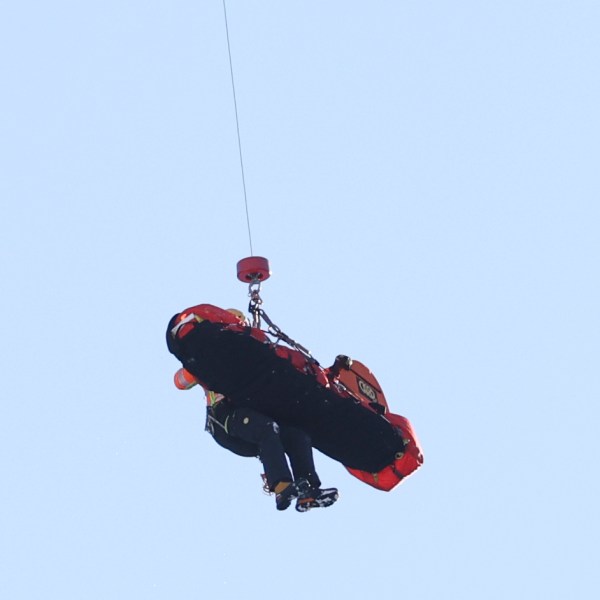 Italy's Pietro Zazzi is lifted by medical staff to an helicopter after crashing during an alpine ski, men's World Cup downhill training, in Bormio, Italy, Friday, Dec. 27, 2024. (AP Photo/Marco Trovati)