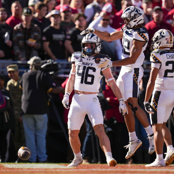 Navy fullback Alex Tecza, (46) celebrates his touchdown run with running backs Eli Heidenreich (22) and Brandon Chatman (24) during the first half of the Armed Forces Bowl NCAA college football game against Oklahoma, Friday, Dec. 27, 2024, in Fort Worth, Texas. (AP Photo/Julio Cortez)