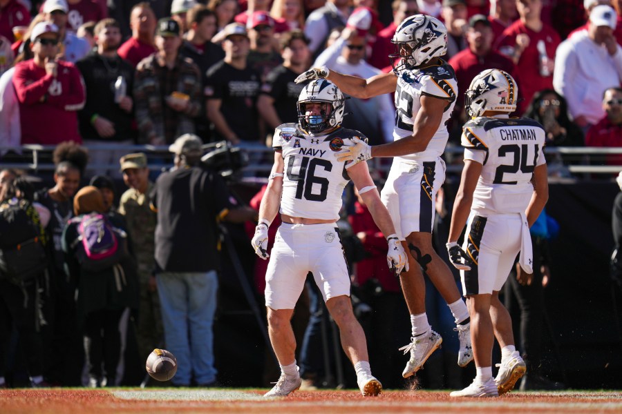 Navy fullback Alex Tecza, (46) celebrates his touchdown run with running backs Eli Heidenreich (22) and Brandon Chatman (24) during the first half of the Armed Forces Bowl NCAA college football game against Oklahoma, Friday, Dec. 27, 2024, in Fort Worth, Texas. (AP Photo/Julio Cortez)