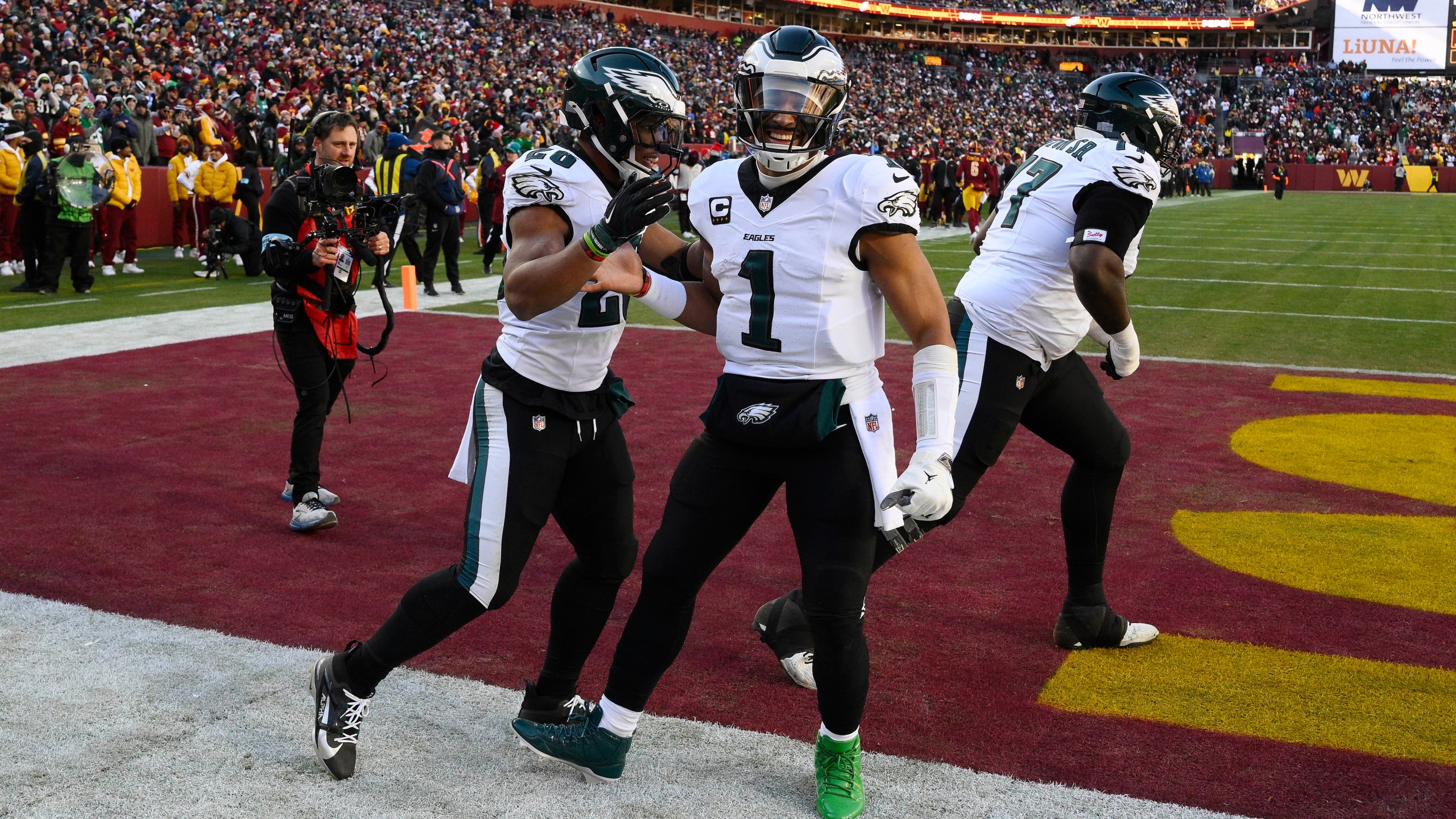 Philadelphia Eagles running back Saquon Barkley (26) celebrating his touchdown with teammate Philadelphia Eagles quarterback Jalen Hurts (1) during the first half of an NFL football game against the Washington Commanders, Sunday, Dec. 22, 2024, in Landover, Md. (AP Photo/Nick Wass)