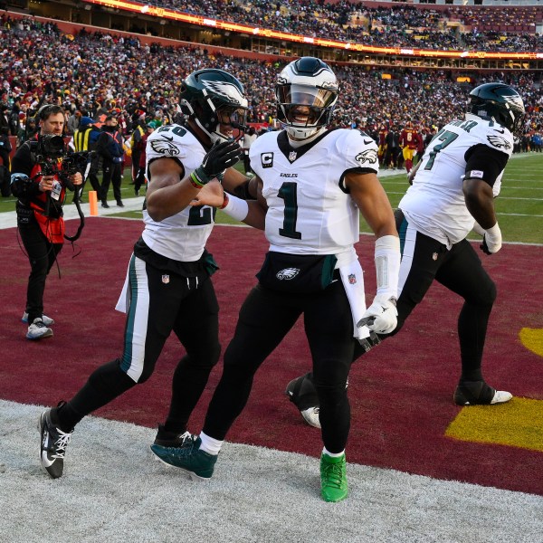 Philadelphia Eagles running back Saquon Barkley (26) celebrating his touchdown with teammate Philadelphia Eagles quarterback Jalen Hurts (1) during the first half of an NFL football game against the Washington Commanders, Sunday, Dec. 22, 2024, in Landover, Md. (AP Photo/Nick Wass)