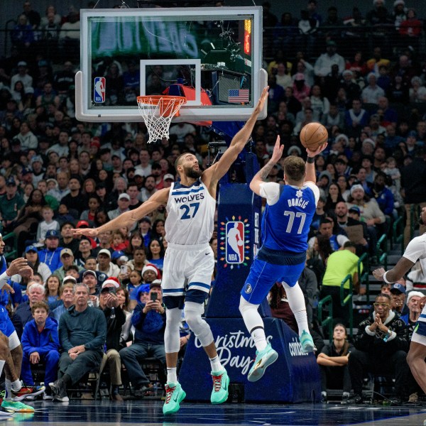 Dallas Mavericks guard Luka Doncic (77) attempts a shot over Minnesota Timberwolves center Rudy Gobert (27) in the first half of an NBA basketball game on Wednesday, Dec. 25, 2024, in Dallas. (AP Photo/Emil T. Lippe)