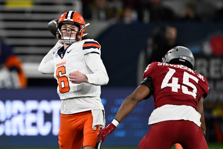 Syracuse quarterback Kyle McCord (6) passes under pressure from Washington State edge Raam Stevenson (45) during the first half of the Holiday Bowl NCAA college football game Friday, Dec. 27, 2024, in San Diego. (AP Photo/Denis Poroy)