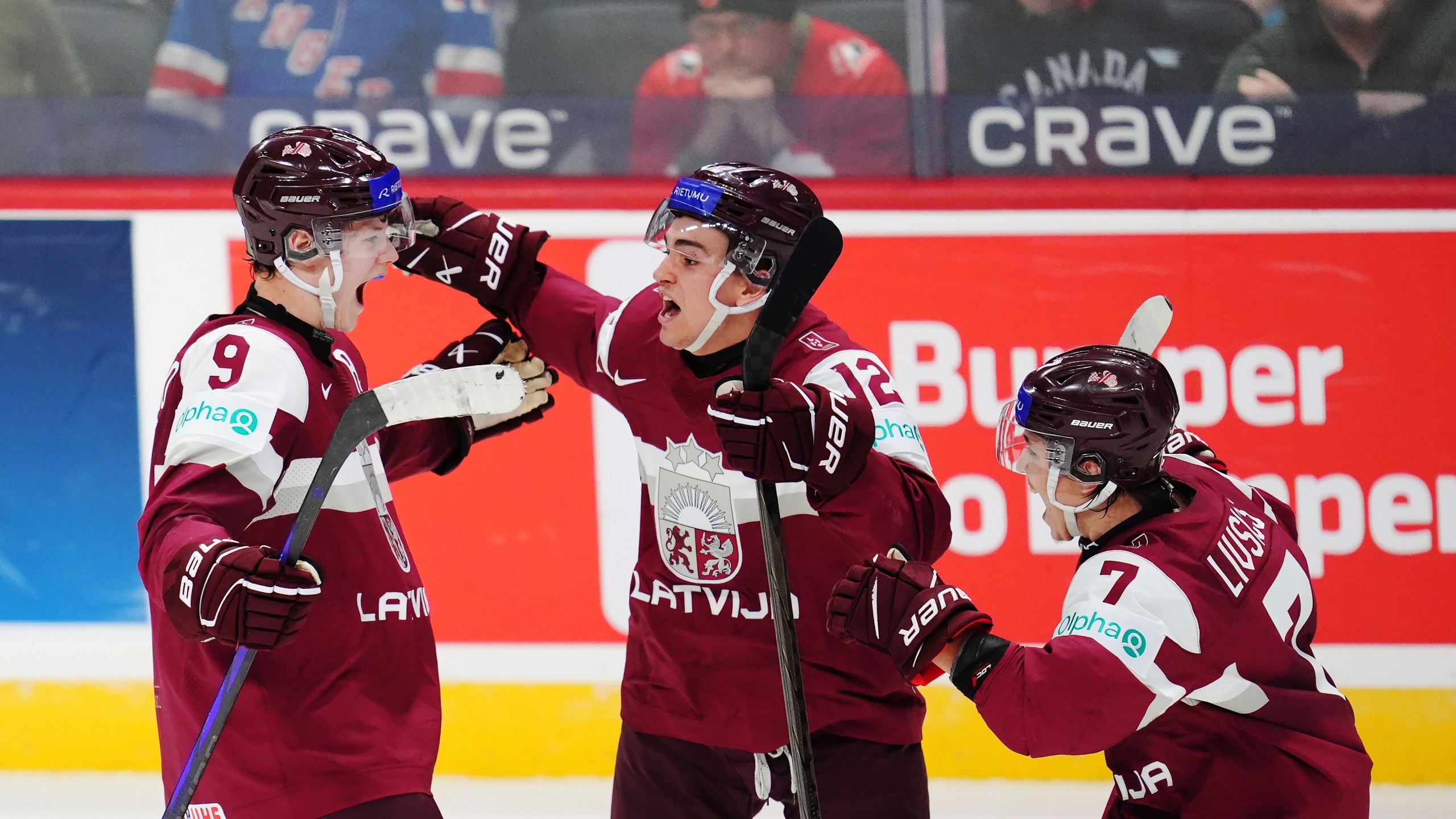 Latvia's Eriks Mateiko, left, celebrates his game-winning shootout goal against Canada with Toms Mots (12) and Davids Livsics (7) in a IIHF World Junior Hockey Championship preliminary round game in Ottawa, Ontario on Friday, Dec. 27, 2024. (Sean Kilpatrick/The Canadian Press via AP)