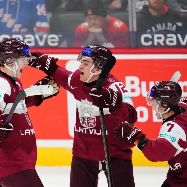 Latvia's Eriks Mateiko, left, celebrates his game-winning shootout goal against Canada with Toms Mots (12) and Davids Livsics (7) in a IIHF World Junior Hockey Championship preliminary round game in Ottawa, Ontario on Friday, Dec. 27, 2024. (Sean Kilpatrick/The Canadian Press via AP)