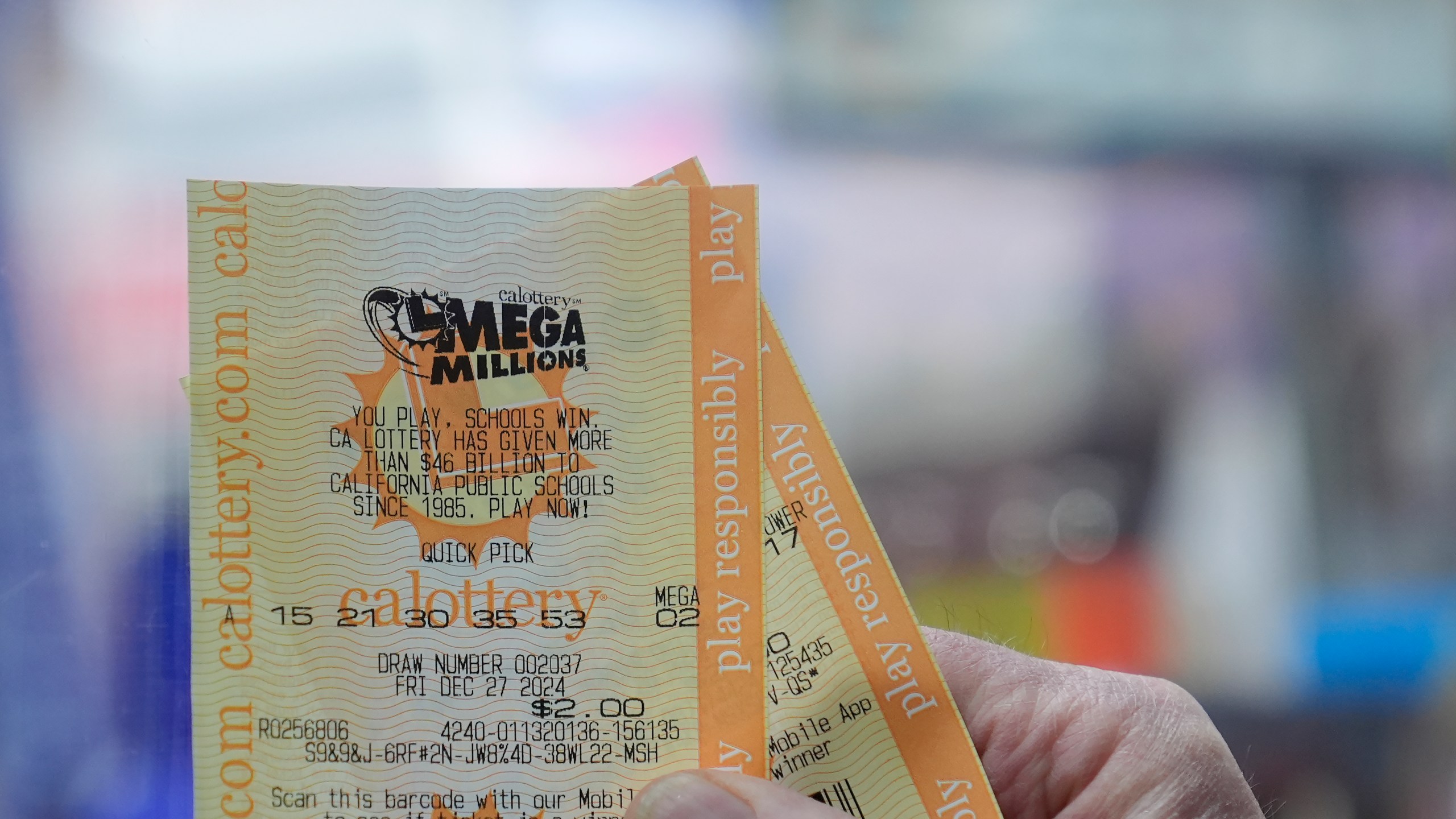 Rob holds up a Mega Millions ticket at Rossi's Deli in San Francisco, Thursday, Dec. 26, 2024. (AP Photo/Jeff Chiu)