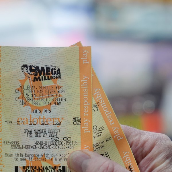 Rob holds up a Mega Millions ticket at Rossi's Deli in San Francisco, Thursday, Dec. 26, 2024. (AP Photo/Jeff Chiu)