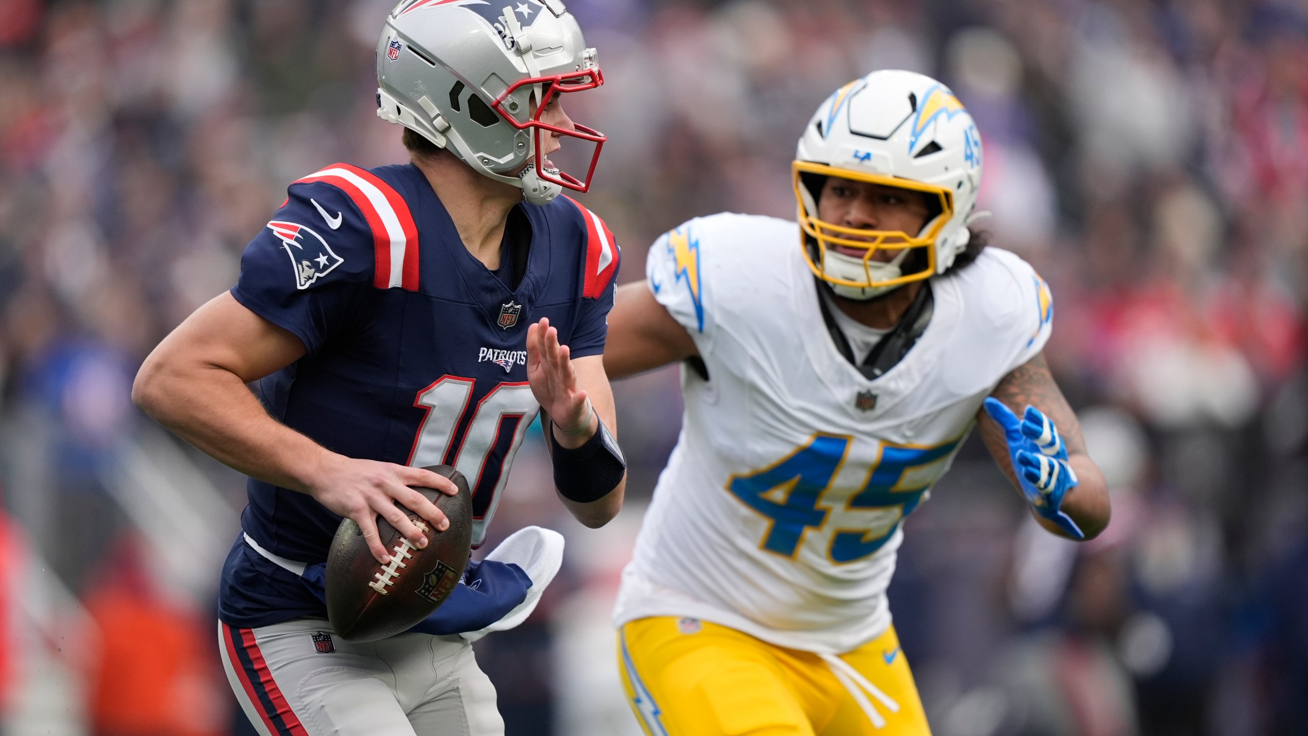 New England Patriots quarterback Drake Maye (10) looks to pass while chased by Los Angeles Chargers linebacker Tuli Tuipulotu (45) during the first half of an NFL football game, Saturday, Dec. 28, 2024, in Foxborough, Mass. (AP Photo/Robert F. Bukaty)