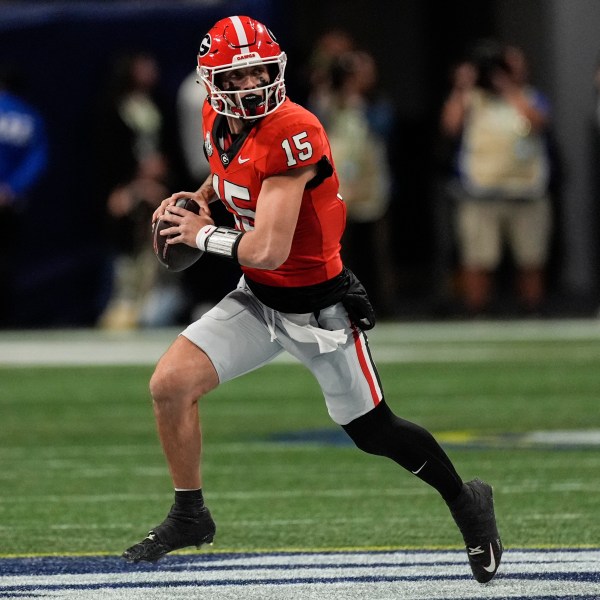 Georgia quarterback Carson Beck (15) runs out of the pocket against Texas during the first half of the Southeastern Conference championship NCAA college football game, Saturday, Dec. 7, 2024, in Atlanta. (AP Photo/John Bazemore)