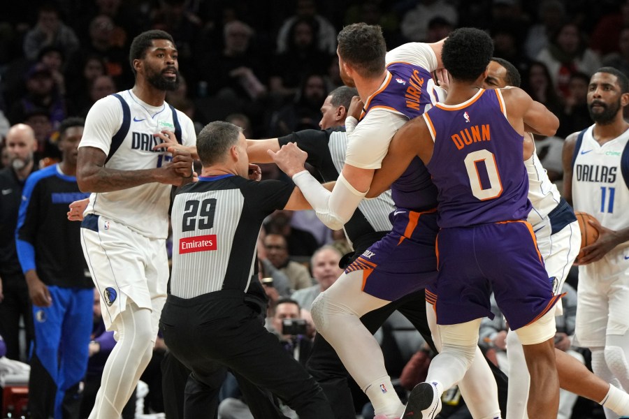 Dallas Mavericks forward Naji Marshall, left, and Phoenix Suns center Jusuf Nurkic have to be separated after fighting during the second half of an NBA basketball game, Friday, Dec. 27, 2024, in Phoenix. Dallas won 98-89. (AP Photo/Rick Scuteri)