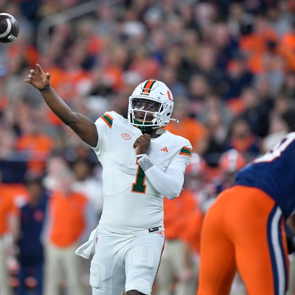 Miami quarterback Cam Ward (1) throws during the first half of an NCAA college football game against Syracuse on Saturday, Nov. 30, 2024 in Syracuse, N.Y. (AP Photo/Adrian Kraus)