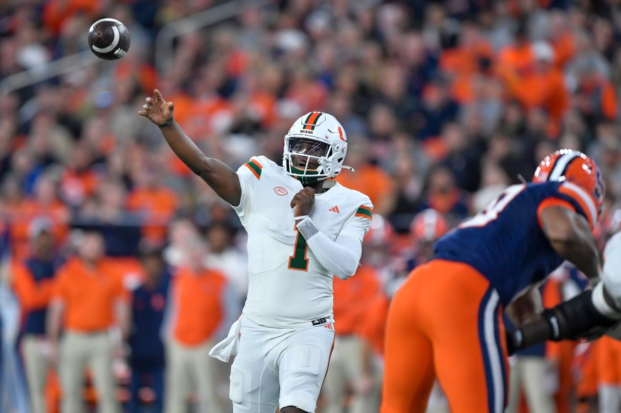 Miami quarterback Cam Ward (1) throws during the first half of an NCAA college football game against Syracuse on Saturday, Nov. 30, 2024 in Syracuse, N.Y. (AP Photo/Adrian Kraus)