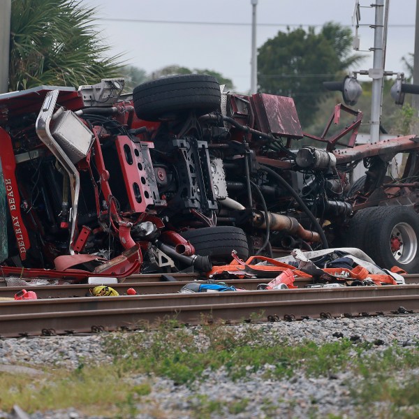 A damaged fire truck is on its side after colliding with a train in downtown Delray Beach, Fla., Saturday, Dec. 28, 2024. (Mike Stocker/South Florida Sun-Sentinel via AP)