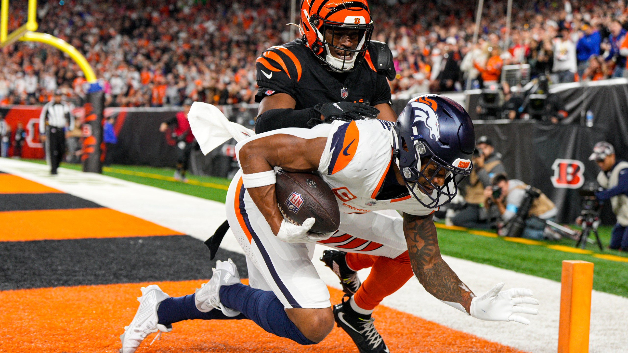 Denver Broncos wide receiver Courtland Sutton (14) makes a catch for a touchdown in front of Cincinnati Bengals cornerback Josh Newton (28) during the second half of an NFL football game in Cincinnati, Saturday, Dec. 28, 2024. (AP Photo/Jeff Dean)