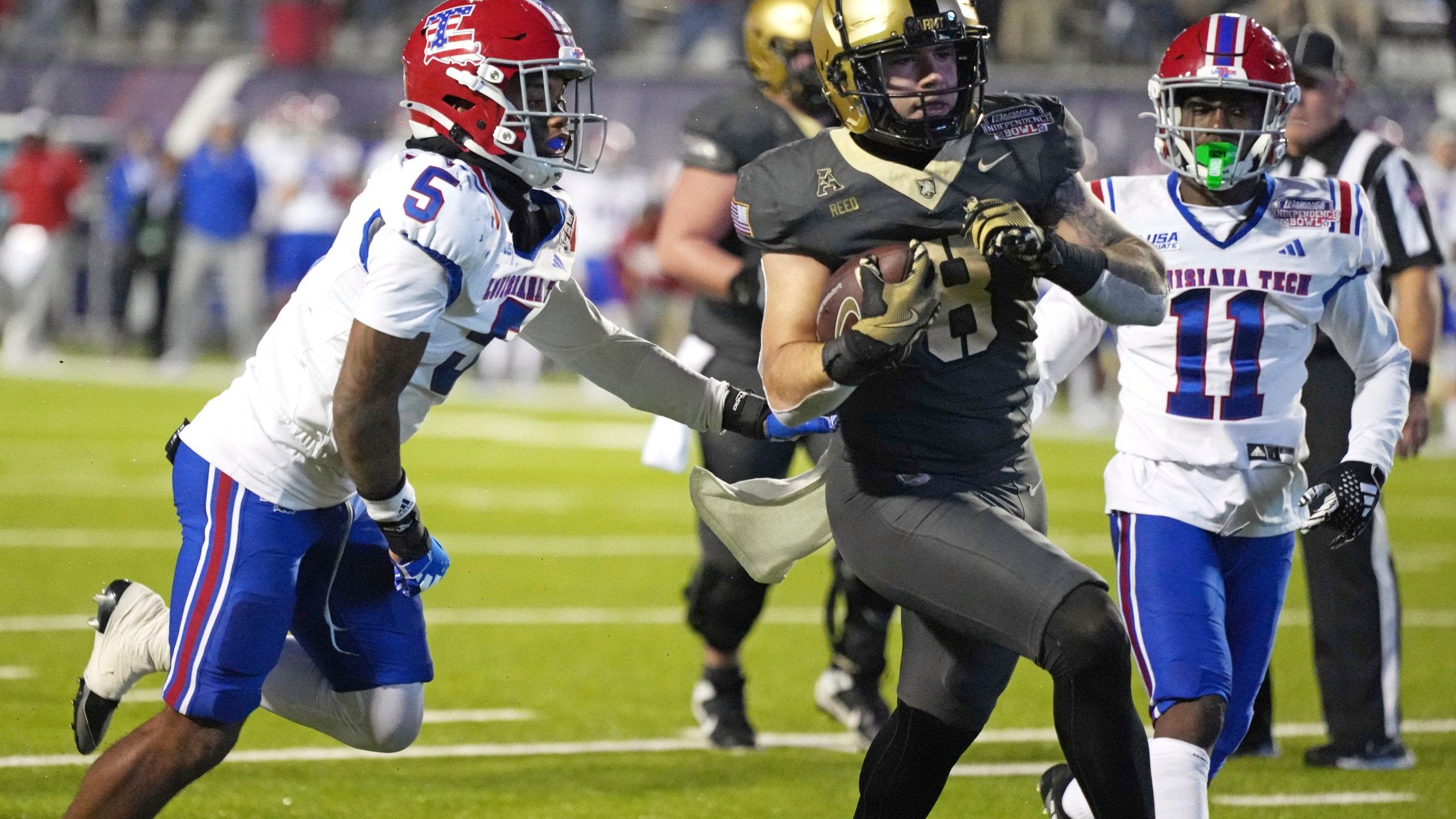 Army running back Hayden Reed (8) runs past Louisiana Tech defensive back Michael Richard (5) on his way to a 12-yard touchdown run during the first half of the Independence Bowl NCAA college football game, Saturday, Dec. 28, 2024, in Shreveport, La. (AP Photo/Rogelio V. Solis)