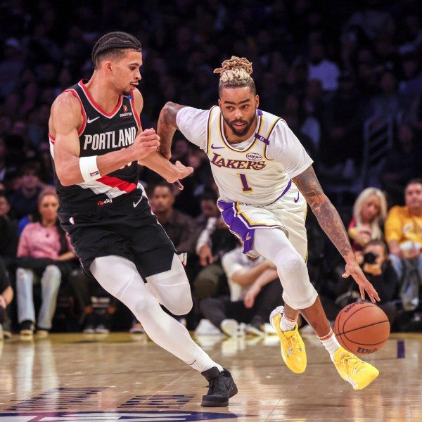 Los Angeles Lakers guard D'Angelo Russell, right, dribbles past Portland Trail Blazers forward Toumani Camara, left, during the first half of an NBA basketball game, Sunday, Dec. 8, 2024, in Los Angeles. (AP Photo/Etienne Laurent)