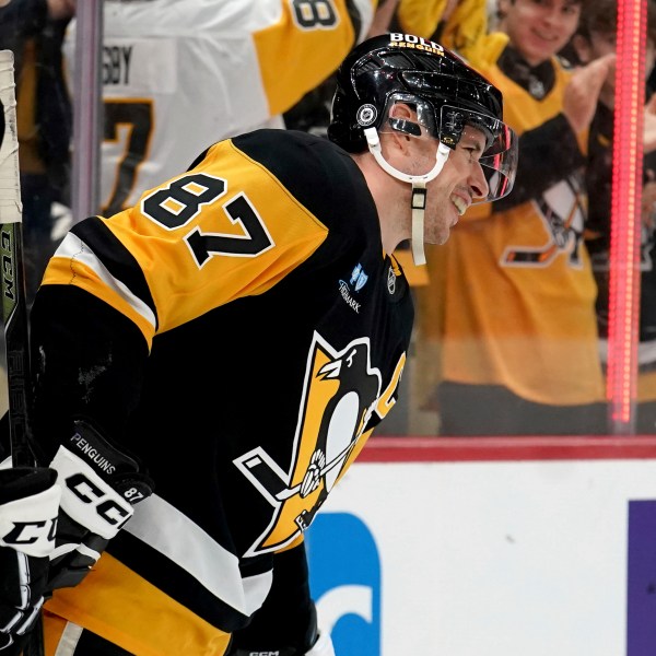 Pittsburgh Penguins' Sidney Crosby (87) celebrates after surpassing Mario Lemieux for the team's all-time leader in assists on a goal by Michael Bunting during the second period of an NHL hockey game against the New York Islanders, Sunday, Dec. 29, 2024, in Pittsburgh. (AP Photo/Matt Freed)