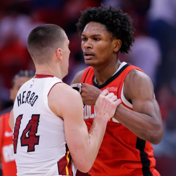 Houston Rockets forward Amen Thompson, right, and Miami Heat guard Tyler Herro (14) tug on each other before Thompson throws Herro to the court sparking a bench clearing brawl resulting in multiple ejections for both teams during the second half of an NBA basketball game Sunday, Dec. 29, 2024, in Houston. (AP Photo/Michael Wyke)