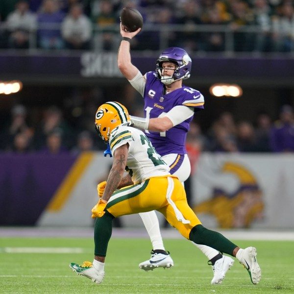 Minnesota Vikings' Sam Darnold throws while being pressured by Green Bay Packers' Keisean Nixon during the first half of an NFL football game Sunday, Dec. 29, 2024, in Minneapolis. (AP Photo/Abbie Parr)