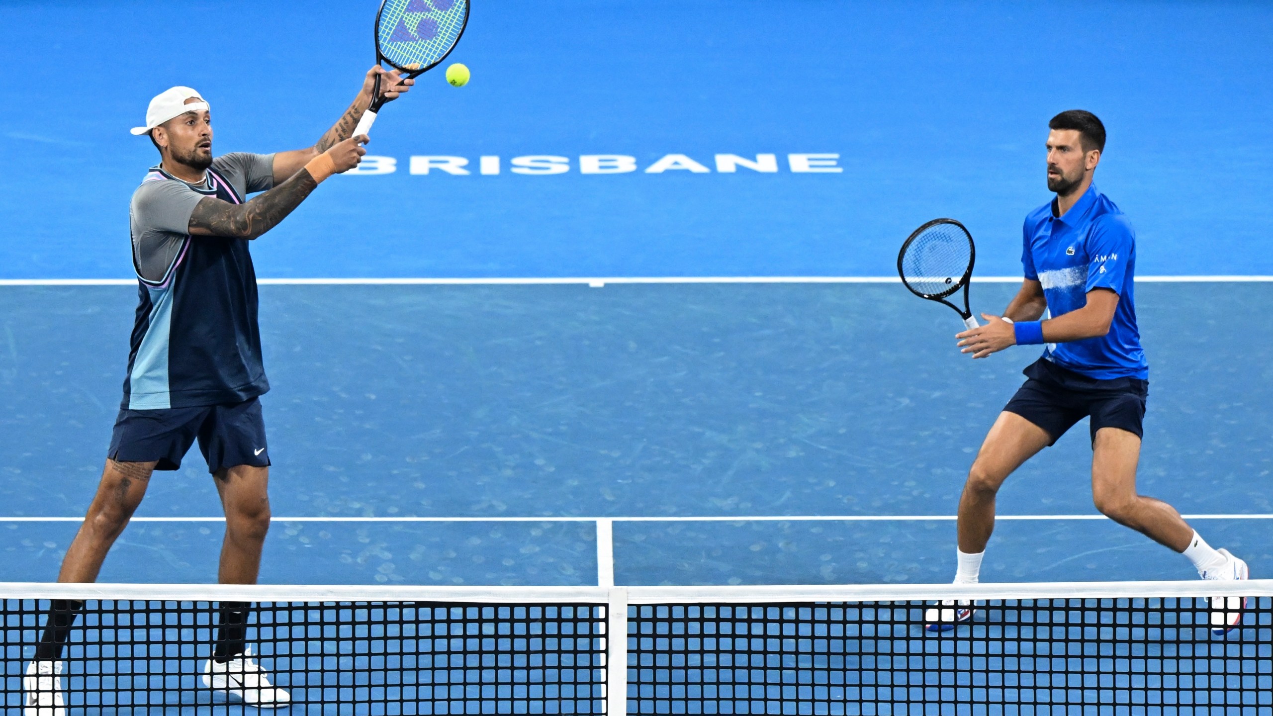 Australia's Nick Kyrgios, left, and Serbia's Novak Djokovic in action during their doubles match against Alexander Erler of Austria and Andreas Mies of Germany in the Brisbane International, at the Queensland Tennis Centre in Brisbane, Australia, Monday, Dec. 30, 2024. (Darren England/AAP Image via AP)