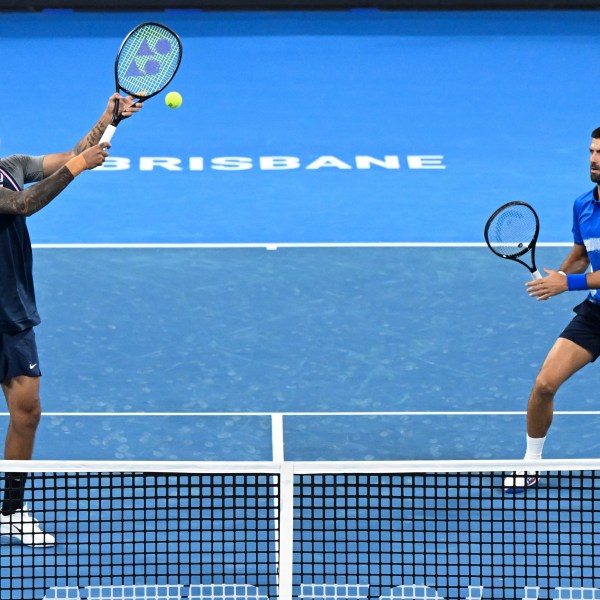 Australia's Nick Kyrgios, left, and Serbia's Novak Djokovic in action during their doubles match against Alexander Erler of Austria and Andreas Mies of Germany in the Brisbane International, at the Queensland Tennis Centre in Brisbane, Australia, Monday, Dec. 30, 2024. (Darren England/AAP Image via AP)