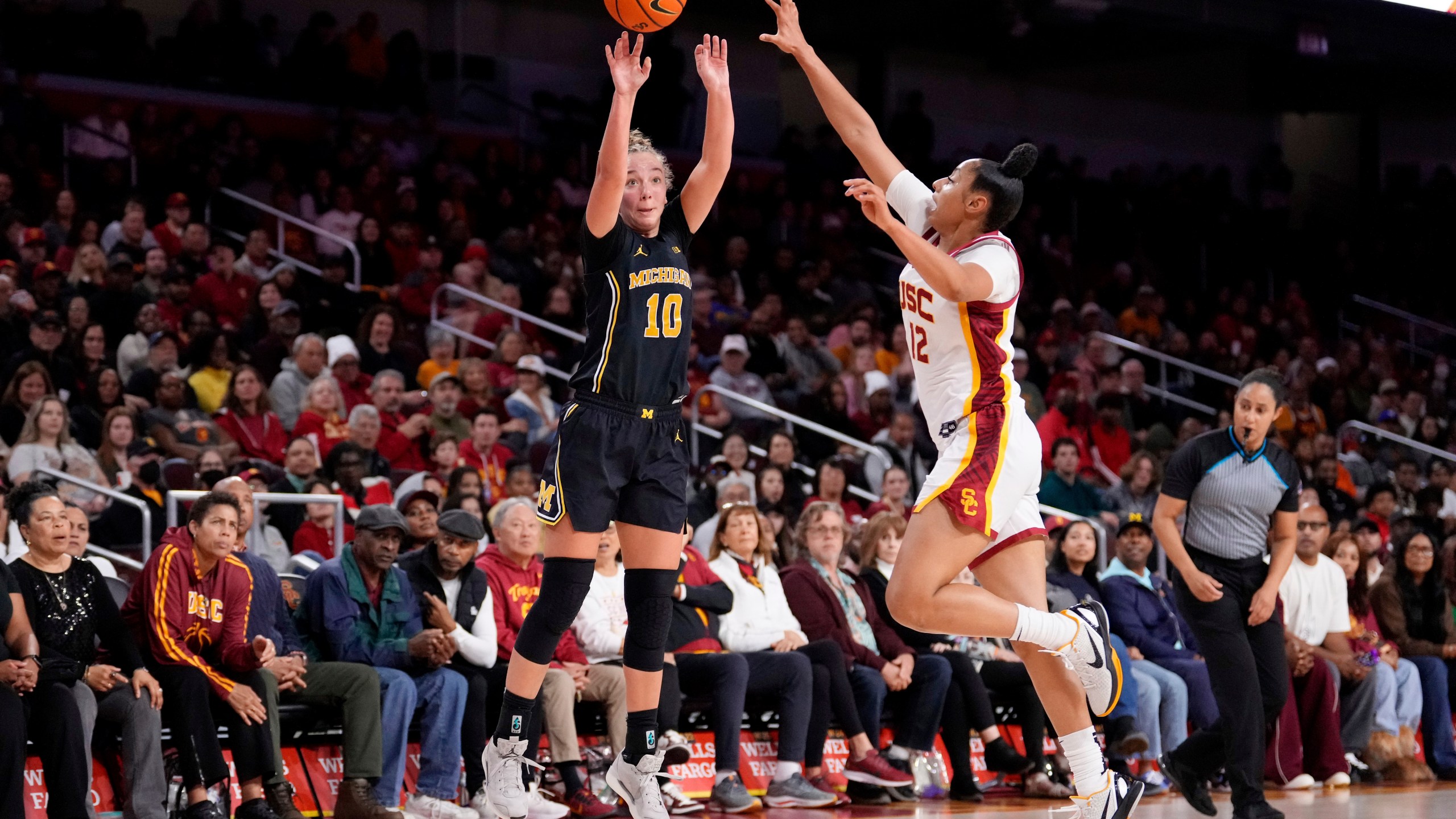 Michigan guard Jordan Hobbs, left, shoots as Southern California guard JuJu Watkins defends during the first half of an NCAA college basketball game, Sunday, Dec. 29, 2024, in Los Angeles. (AP Photo/Mark J. Terrill)