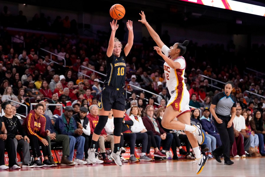 Michigan guard Jordan Hobbs, left, shoots as Southern California guard JuJu Watkins defends during the first half of an NCAA college basketball game, Sunday, Dec. 29, 2024, in Los Angeles. (AP Photo/Mark J. Terrill)