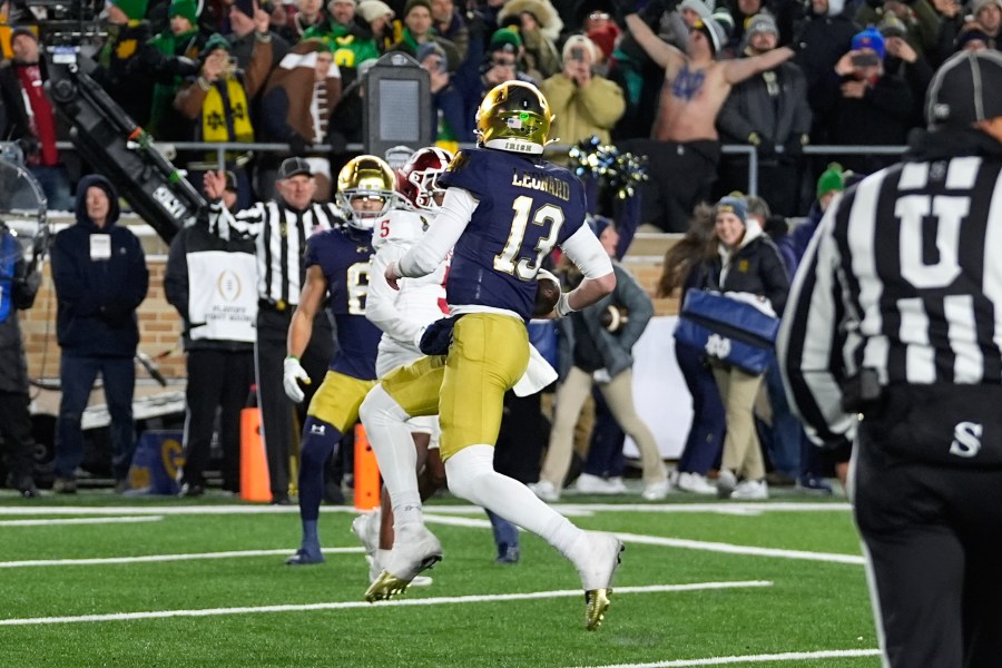 Notre Dame quarterback Riley Leonard (13) runs for a one-yard touchdown against Indiana for a during the second half in the first round of the College Football Playoff, Friday, Dec. 20, 2024, in South Bend, Ind. (AP Photo/Darron Cummings)