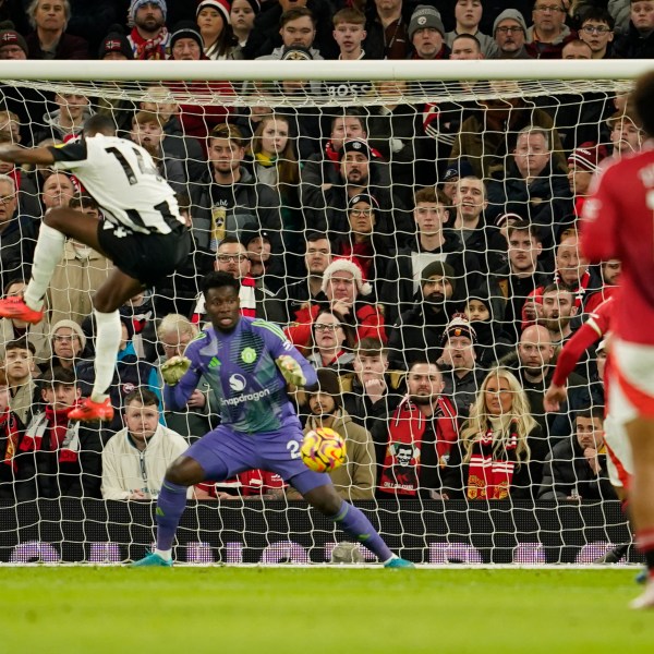 Newcastle's Alexander Isak, left, scores his side's opening goal during the English Premier League soccer match between Manchester United and Newcastle at the Old Trafford stadium in Manchester, England, Monday, Dec. 30, 2024. (AP Photo/Dave Thompson)