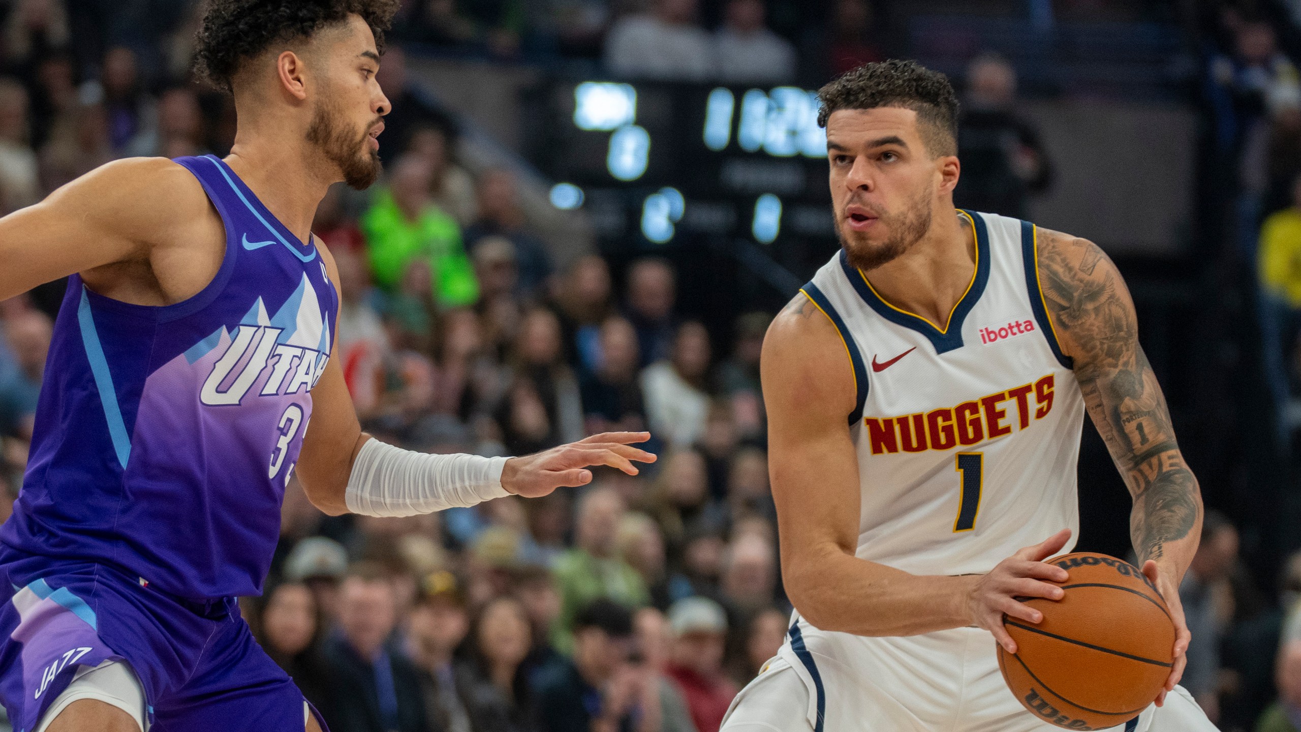 Denver Nuggets forward Michael Porter Jr. (1) looks to shoot as Utah Jazz guard Johnny Juzang, left, defends during the first half of an NBA basketball game Monday, Dec. 30, 2024, in Salt Lake City. (AP Photo/Rick Egan)